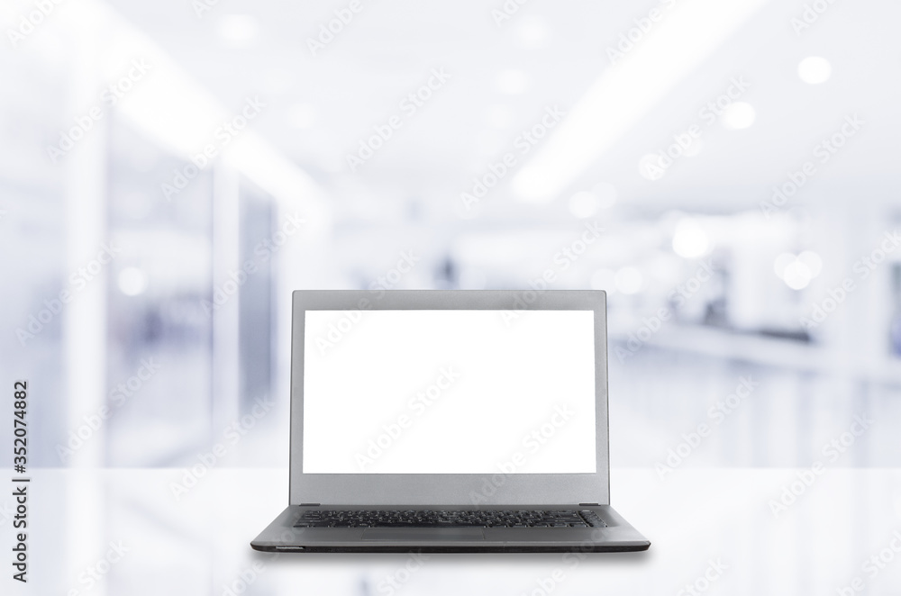 Fototapeta premium laptop computer blank white screen open front display on white table with blur room indoor background with reflection. technology mockup device black and grey color.