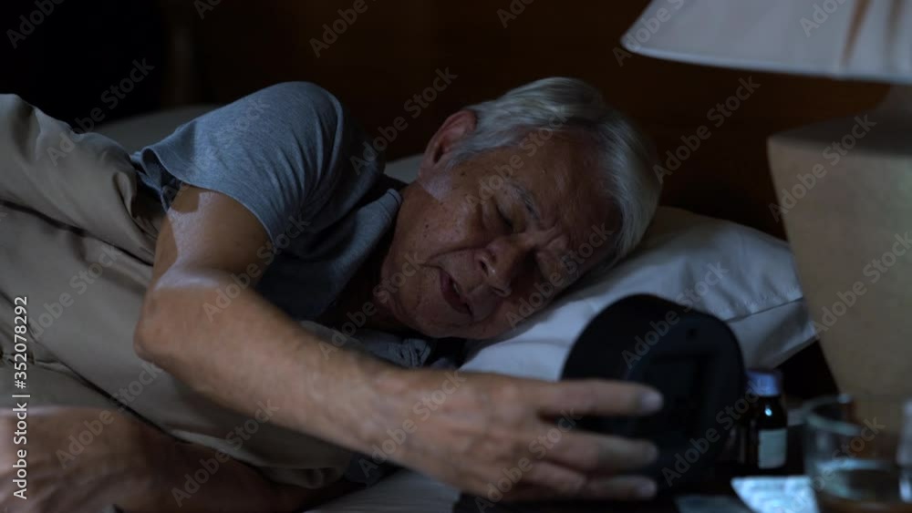Depressed senior person sitting in bed cannot sleep from insomnia Depressed senior person sitting in bed cannot sleep from insomnia