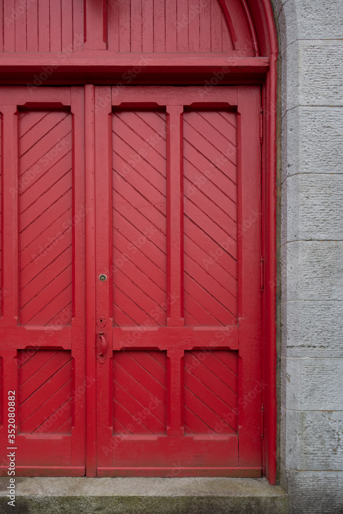 old big red wooden entrance door way with cement blocks old big red wooden entrance door way with cement blocks