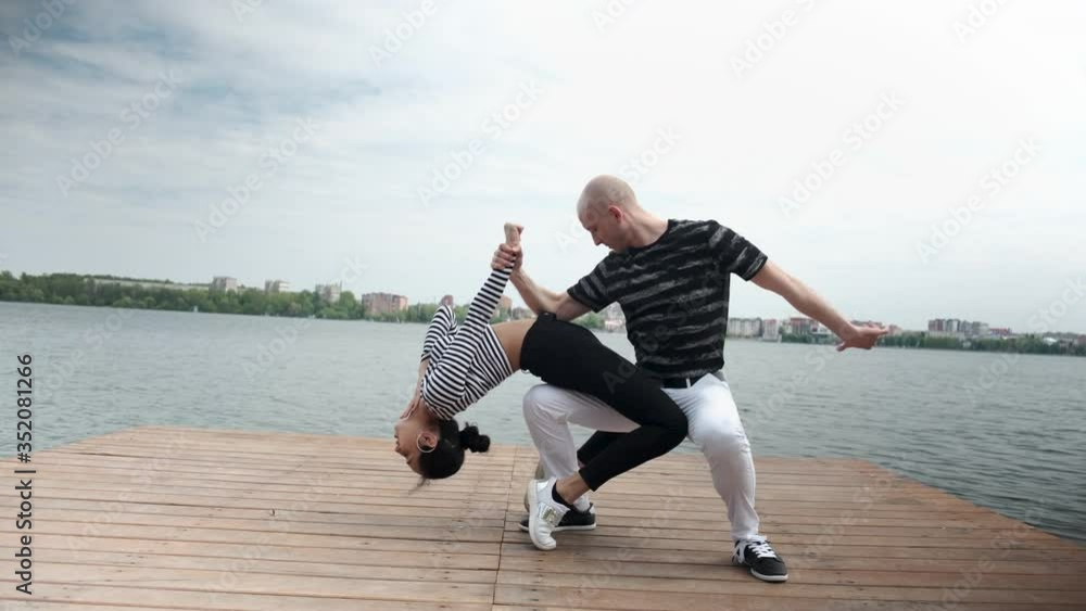 The couple in love dance social dance bachata pier on the lake, town horizon The couple in love dance social dance bachata pier on the lake, town horizon