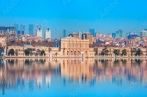 Dolmabahce Palace  Dolmabahce Sarayi  seen from the Bosphorus - Dolmabahce palace against coastal cityscape with modern buildings - Istanbul  Turkey