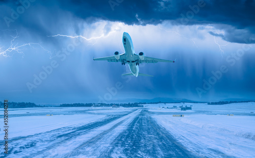 White Passenger plane fly up over take-off runway from airport - An airplane flies in bad weather and storm with lightning 