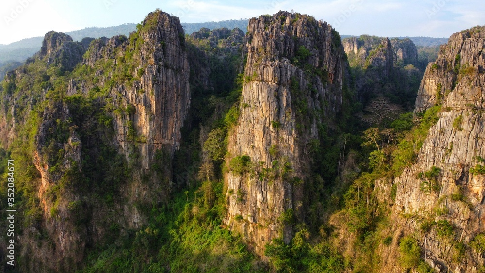 Rock mountain hills peak at sunrise with beautiful Rock in morning light. Thailand National Park , Aerial Drone Flight top down View.	