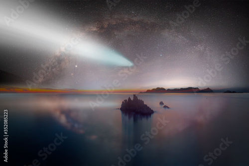 The milky way galaxy in the night sky on the background comet - Long exposure image of Dramatic sky and seascape with rock © muratart
