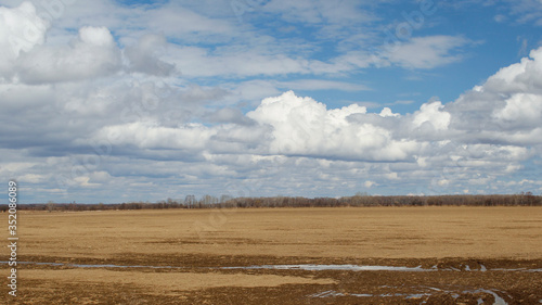 Spring clouds over a wide spring field