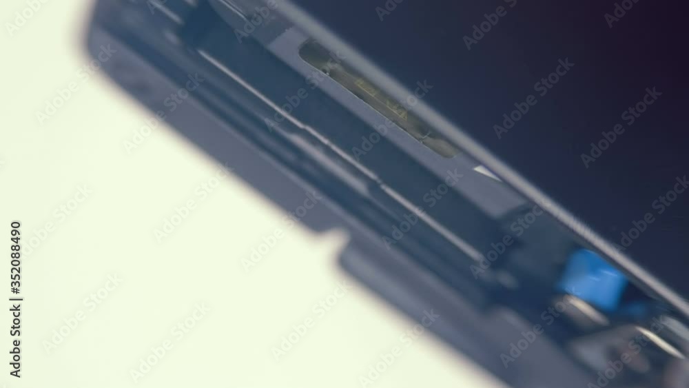A man pulls out a SD card from the camera (digital device) to drop data to a computer, then inserts it back. Macro. Closeup. Shallow depth of field A man pulls out a SD card from the camera (digital device) to drop data to a computer, then inserts it back. Macro. Closeup. Shallow depth of field
