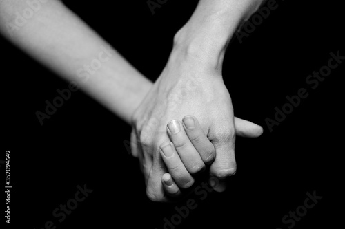Black and white mother and daughter holding hands. Helping hands