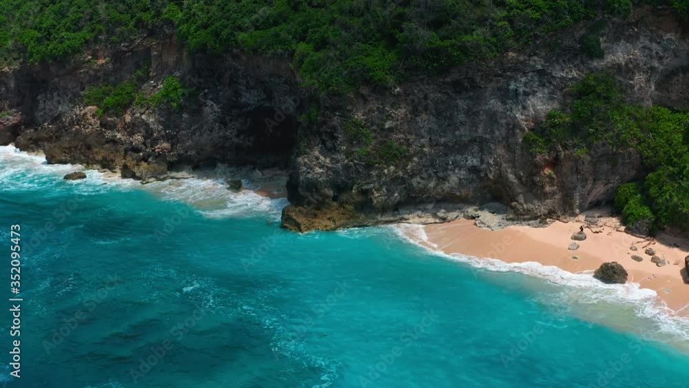 Aerial view of ocean blue waves break on high cliff of a rocky mountain. Danger sea waves on a beach aerial view drone shot. Bird's eye view of ocean waves crashing on a big stones on empty stone. Aerial view of ocean blue waves break on high cliff of a rocky mountain. Danger sea waves on a beach aerial view drone shot. Bird's eye view of ocean waves crashing on a big stones on empty stone.