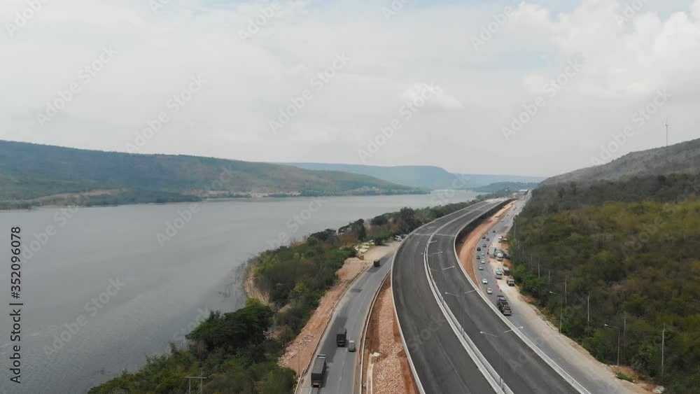 Drone shot aerial view scenic landscape of under-construction motorway and highway bridge, nearly natural big river mountain and forest Drone shot aerial view scenic landscape of under-construction motorway and highway bridge, nearly natural big river mountain and forest