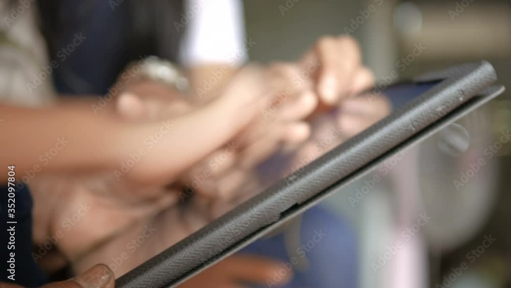 Hands of grandmother and child using tablet, metaphor a family learning how to use mobile technology with a difference of age, select focus shallow depth of field Hands of grandmother and child using tablet, metaphor a family learning how to use mobile technology with a difference of age, select focus shallow depth of field