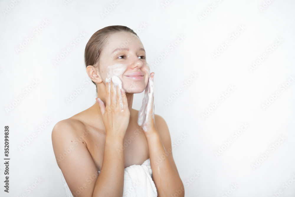 A beautiful caucasian woman washes her skin on her face and smiles. Happy healthy woman. Skin care. Pore cleansing.