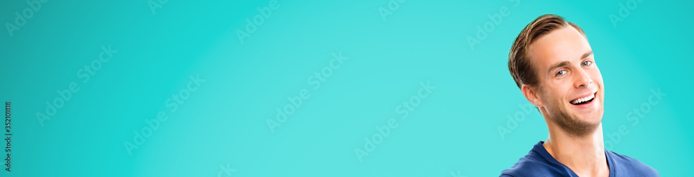 Fototapeta premium Face portrait - very happy man over aqua marine blue color background. Excited male model with open mouth, in smart casual wear at studio picture. Wide horizontal banner composition. Copy space area.