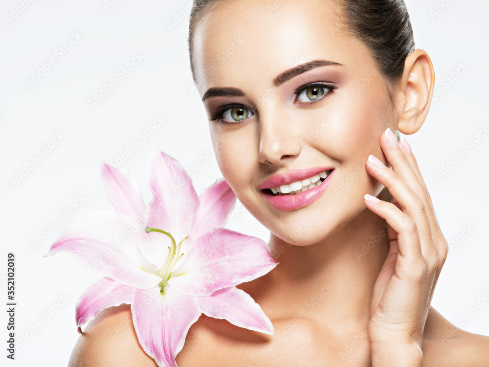 Beauty face of young beautiful smiling woman with flower Beauty face of young beautiful smiling woman with flower