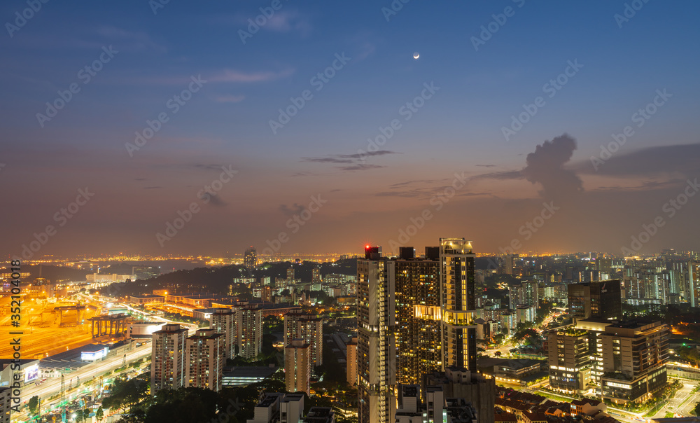 Views of Singapore during the night after sunset. The lights from the city's high buildings, ports and roads and beautiful skies in cityscape concept.