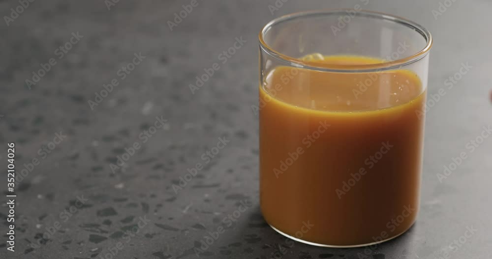 Slow motion man hand take glass of fresh sea buckthorn juice from concrete surface Slow motion man hand take glass of fresh sea buckthorn juice from concrete surface
