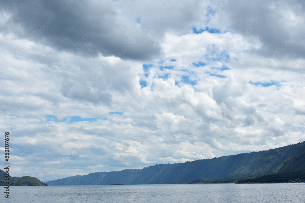 Lake Toba view with blue sky. A large natural lake in Sumatra, Indonesia, occupying the caldera of a supervolcano.