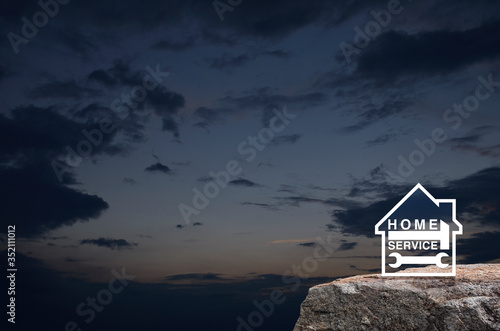 Hammer and wrench with house flat icon on rock mountain over sunset sky, Business home service concept