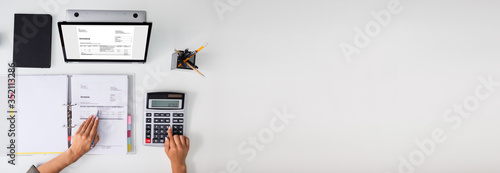 Accountant calculating tax at desk photo