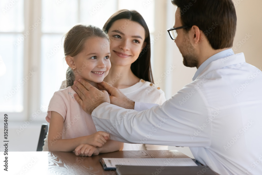 Male doctor do checkup consult cute little girl visiting with young mom in clinic, man pediatrician or physician examine small child at regular family consultation in hospital, healthcare concept Male doctor do checkup consult cute little girl visiting with young mom in clinic, man pediatrician or physician examine small child at regular family consultation in hospital, healthcare concept