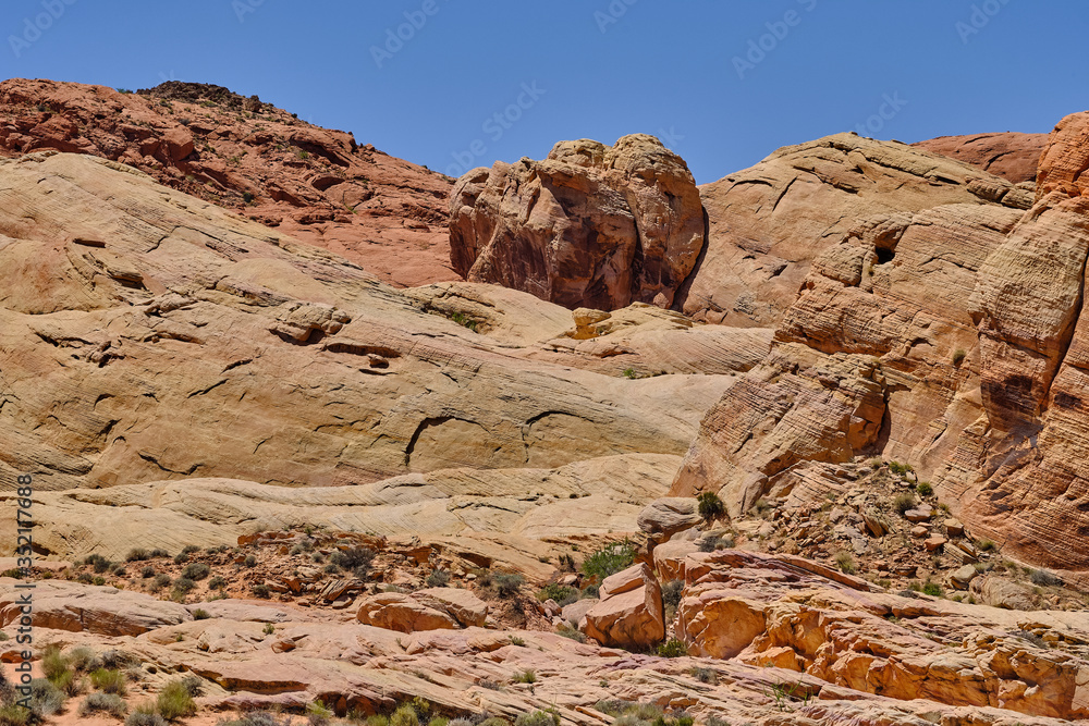 Large boulder dropped off with the last glacier sits atop sandstone formations in the Nevada Desert