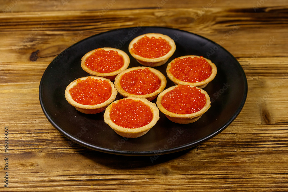 Tartlets with red caviar on a wooden table Tartlets with red caviar on a wooden table
