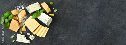 Photos Cheese set: brie, blue cheese, parmesan and basil on a black concrete background