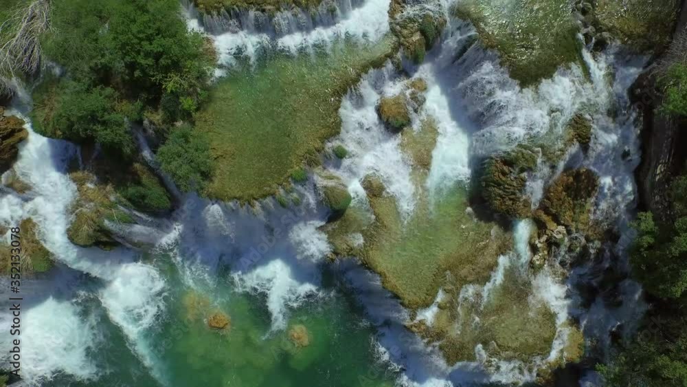Aerial top view of river flowing on rock formation during sunny day, drone flying over waterfall - Krka, Croatia Aerial top view of river flowing on rock formation during sunny day, drone flying over waterfall - Krka, Croatia