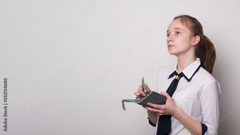 Portrait of a girl holding money dollars. Caucasian girl holding a wallet with money. Banner with blank space for text. Portrait of a girl holding money dollars. Caucasian girl holding a wallet with money. Banner with blank space for text.