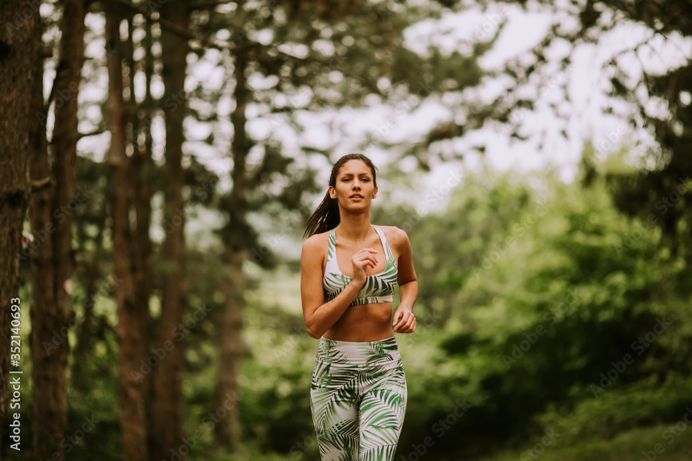 Young fitness woman running at forest trail Young fitness woman running at forest trail