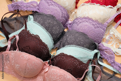 Brassieres of different colors are folded in a dresser. Pink, green, gray and brown bra with lace top view. Sexy fashion underwear. Woman underwear concept for fashion blogging or shopping