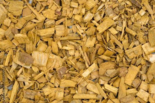 Yellow wood chips background. Painted wood chips for decorating and decorating flower beds and trees. Natural mulch for landscape design.