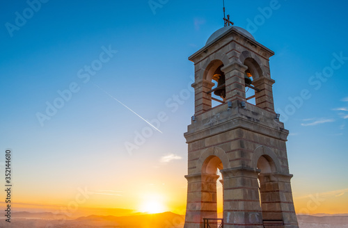 Sunset view of bell tower of St. George chapel on top of Mount Lycabettus, Lycabettus hill, in historic Kolonaki quarter of Athens, Greece photo
