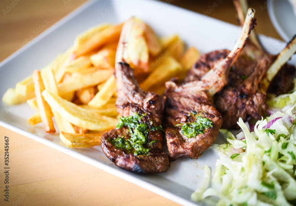 delicious grilled lamb chopsticks with french fries, pesto sauce & mix of lettuces