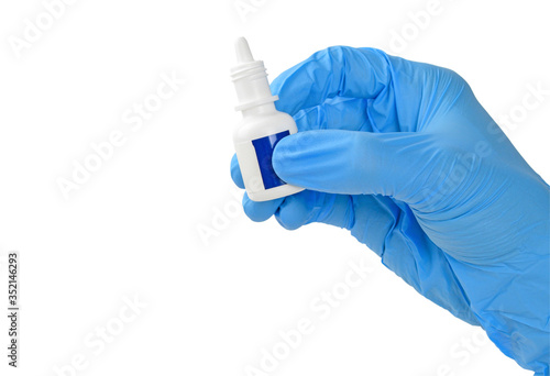 Human hand in medical glove is holding medicine or eye drop container isolated on white background with clipping path.