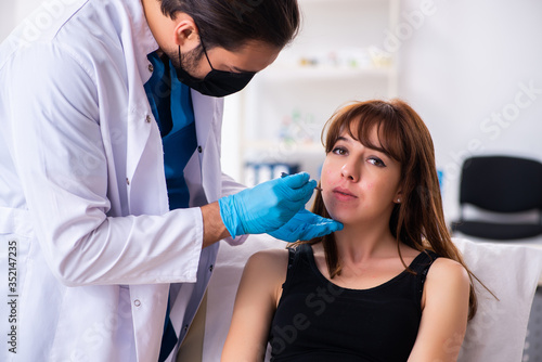 Young woman visiting male doctor dermatologist