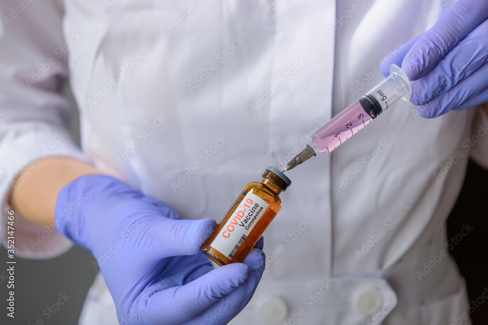 Doctor's hands in medical gloves filling a syringe with the covid 19 vaccine. Nurse holding syringe and new coronavirus vaccine. Healthcare And Medicine concept. Doctor's hands in medical gloves filling a syringe with the covid 19 vaccine. Nurse holding syringe and new coronavirus vaccine. Healthcare And Medicine concept.