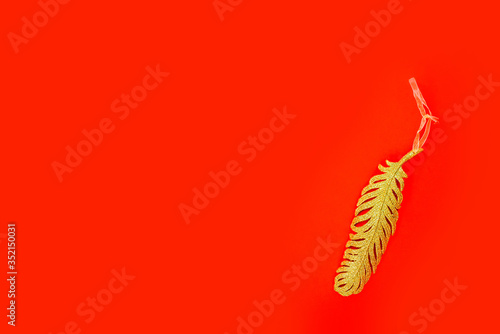 Golden glitter feather with rubbon  christmas background.