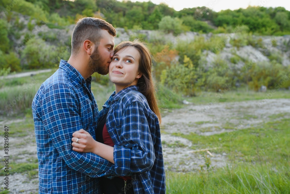 Couple enjoying beautiful views on the mountains, while traveling with backpacks in the mountains during the summer vacations Couple enjoying beautiful views on the mountains, while traveling with backpacks in the mountains during the summer vacations