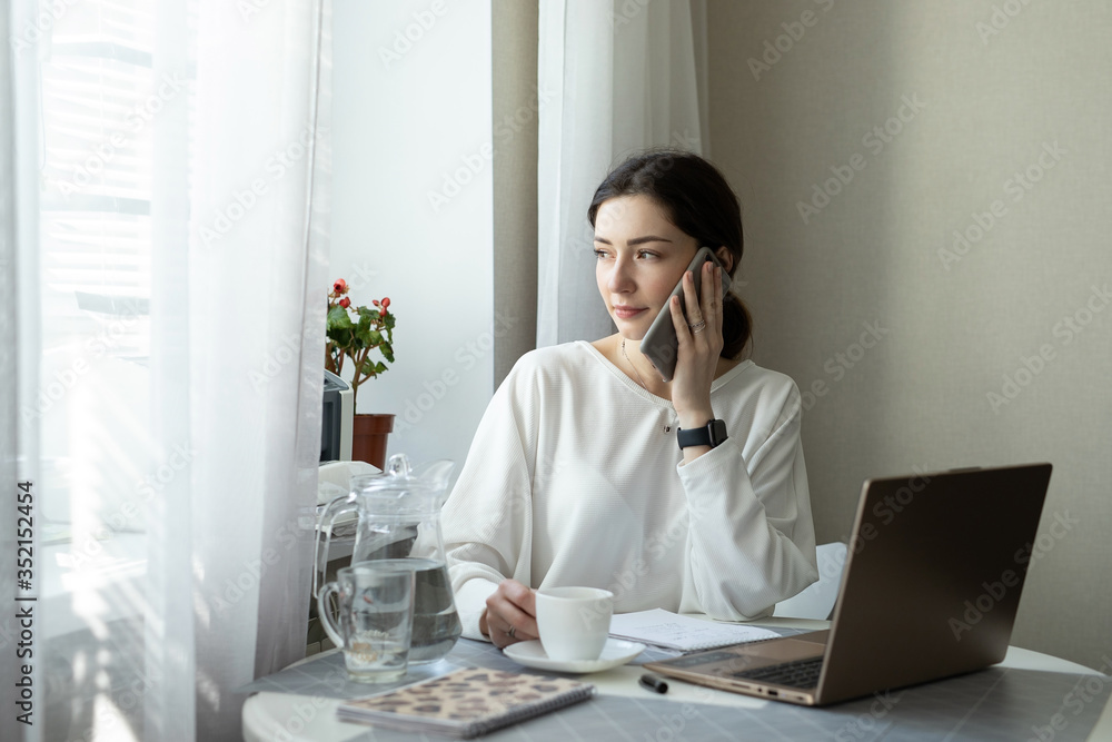 Businesswoman consults by phone and drink coffee at home Businesswoman consults by phone and drink coffee at home