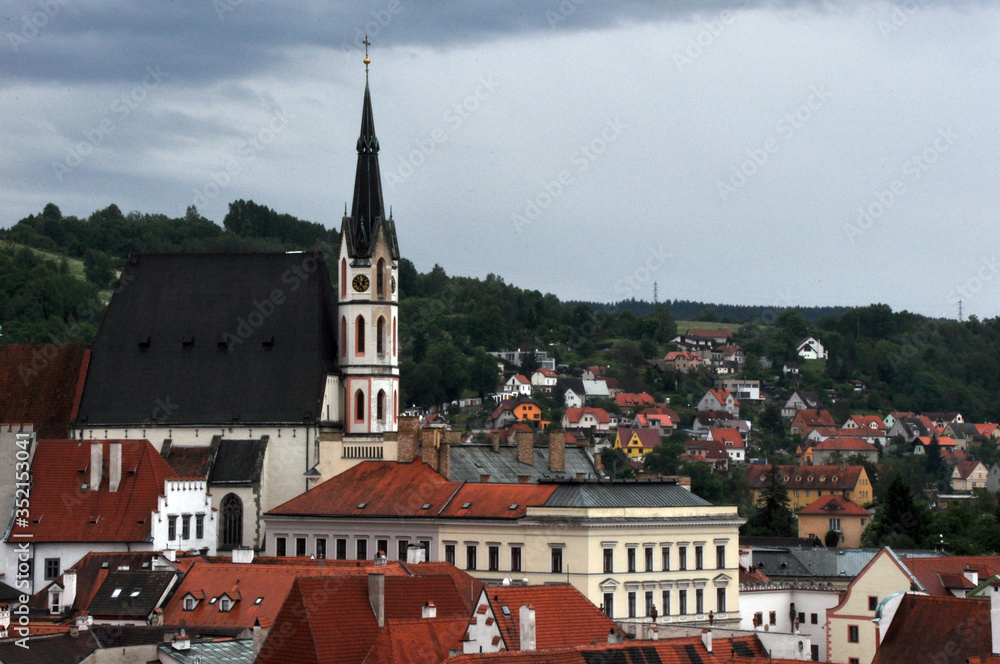 Panorama of tiled roofs of houses in the historic city of Cesky Krumlov. View of the St. Vitus Church.
