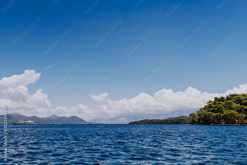 Greek Island viewed from the sea. Beautiful sea landscapes on Island in Greece. In distance is famous Scorpios island, from the left side is Lefkada island and from right is a part of gorgeous Greek Island viewed from the sea. Beautiful sea landscapes on Island in Greece. In distance is famous Scorpios island, from the left side is Lefkada island and from right is a part of gorgeous