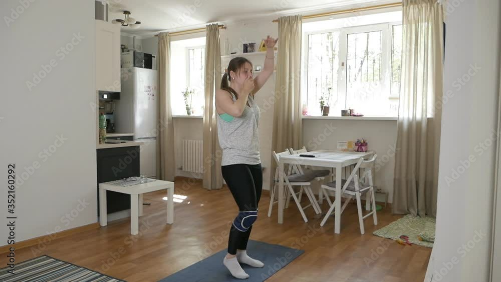 Beautiful slim woman doing morning cardio exercises, in sportswear in a modern room Beautiful slim woman doing morning cardio exercises, in sportswear in a modern room