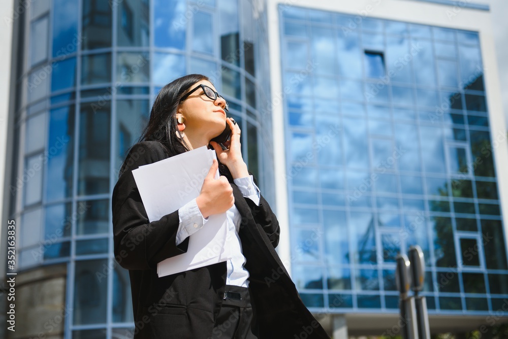 Girl with documents at a business meeting near a modern building Girl with documents at a business meeting near a modern building