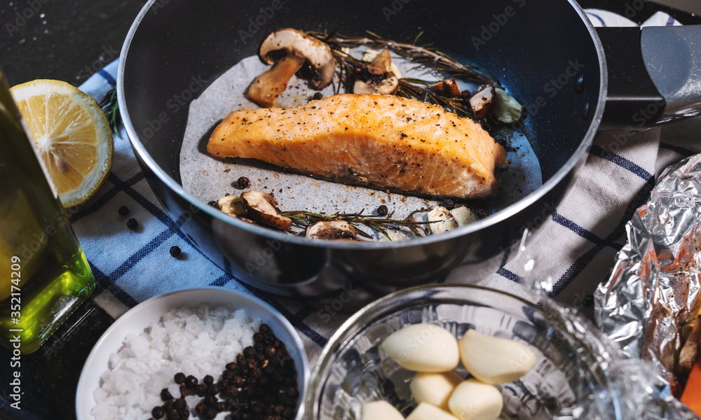 Steak salmon fillet in frying pan surrounding with ingredients Steak salmon fillet in frying pan surrounding with ingredients