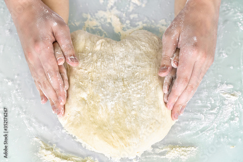 mom's and baby's hands form a heart-shaped yeast dough. concept of love and family values