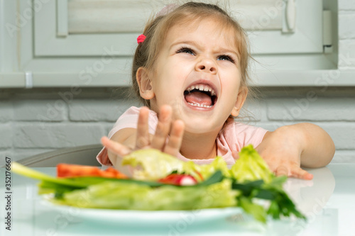 a girl 4 years emotionally repels a plate of vegetables from herself. lack of fruits and vegetables in children's diets