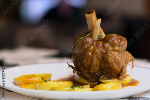Photos Baked pork knuckle recipe with golden apple slices, thyme, vegetables and white