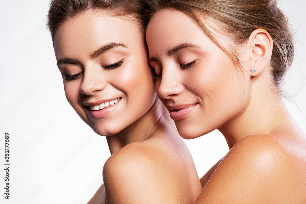 Close up sensual portrait of brunette women girlfriends with flawless fresh skin. Studio portrait on white background. Cosmetics concept Close up sensual portrait of brunette women girlfriends with flawless fresh skin. Studio portrait on white background. Cosmetics concept