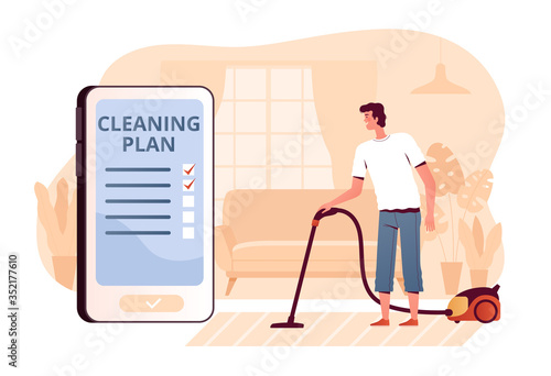A young man vacuums a carpet at home in the living room. The concept of a mobile application for cleaning planning