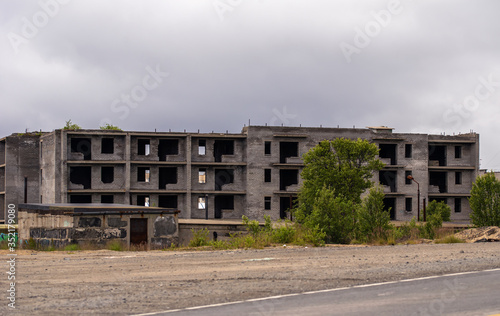 Facade of abandoned grey multi-storey soviet panel building